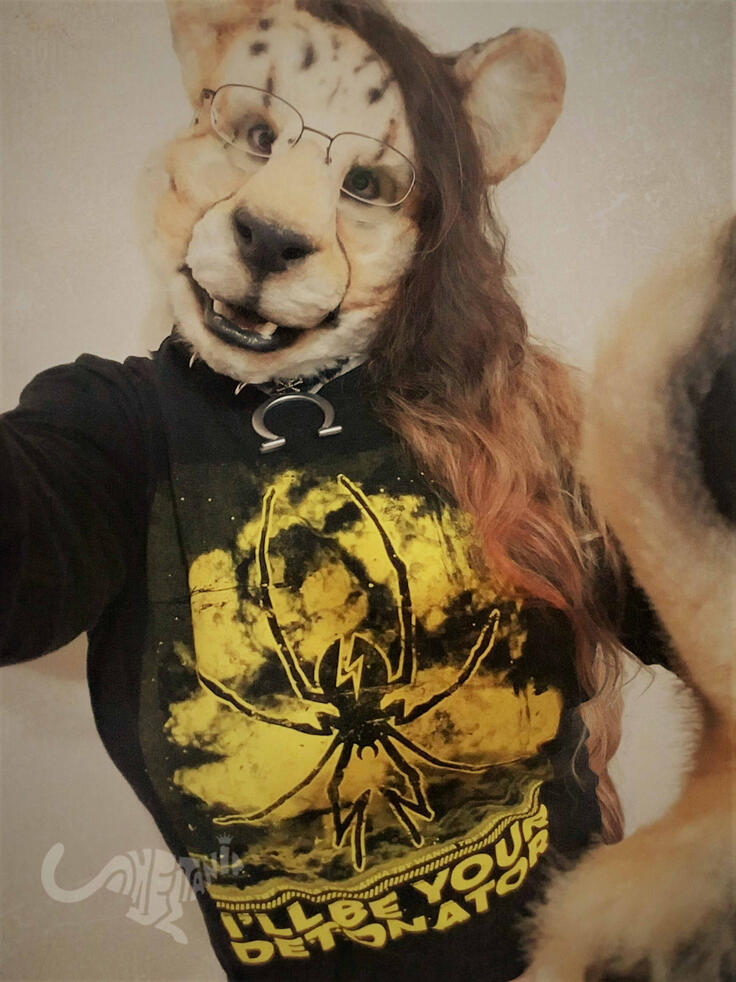 Shetani posing in a spiked leather choker and My Chemical Romance shirt with a mushroom cloud graphic. Distressed desert editing