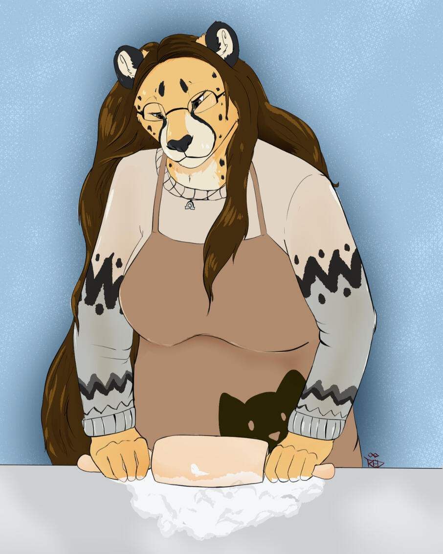 Art of Shetani baking, wearing a cat apron over a gray striped sweater