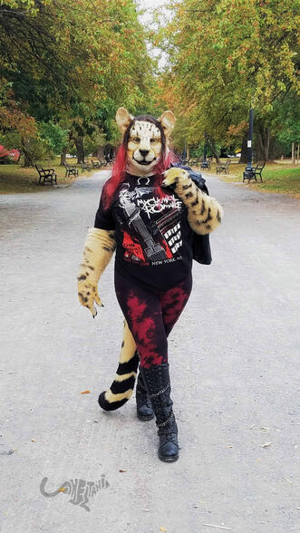 Shetani walking down a tree-lined park path wearing a MCR shirt, knee-high leather boots, leggings, and a leather jacket Shetani walking down a tree-lined park path wearing a MCR shirt, knee-high leather boots, leggings, and a leather jacket