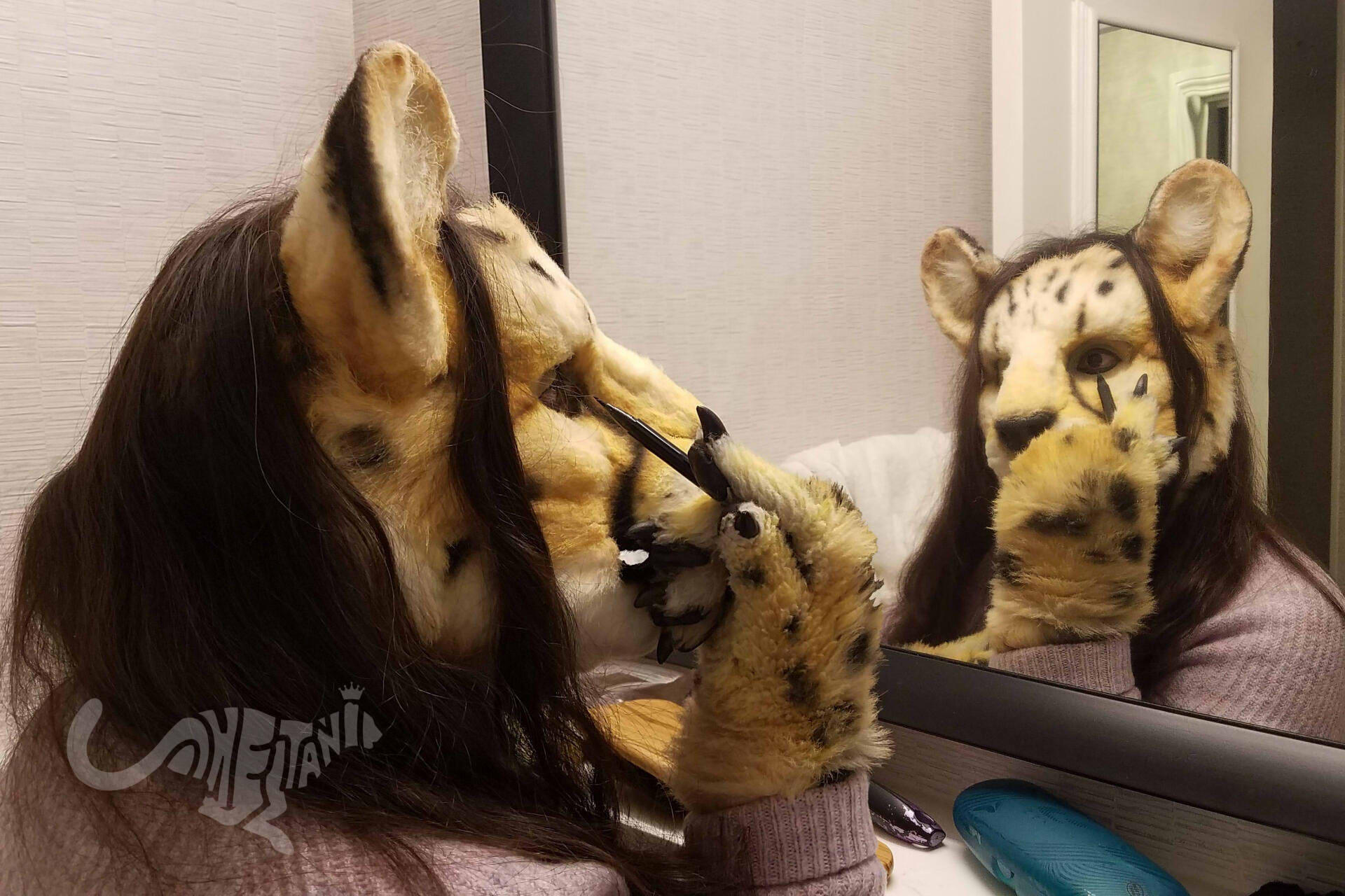 Shetani in fursuit looking in a mirror and applying eyeliner.