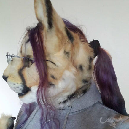 Profile shot of Shetani with her purple-dyed hair pulled back in a loose ponytail