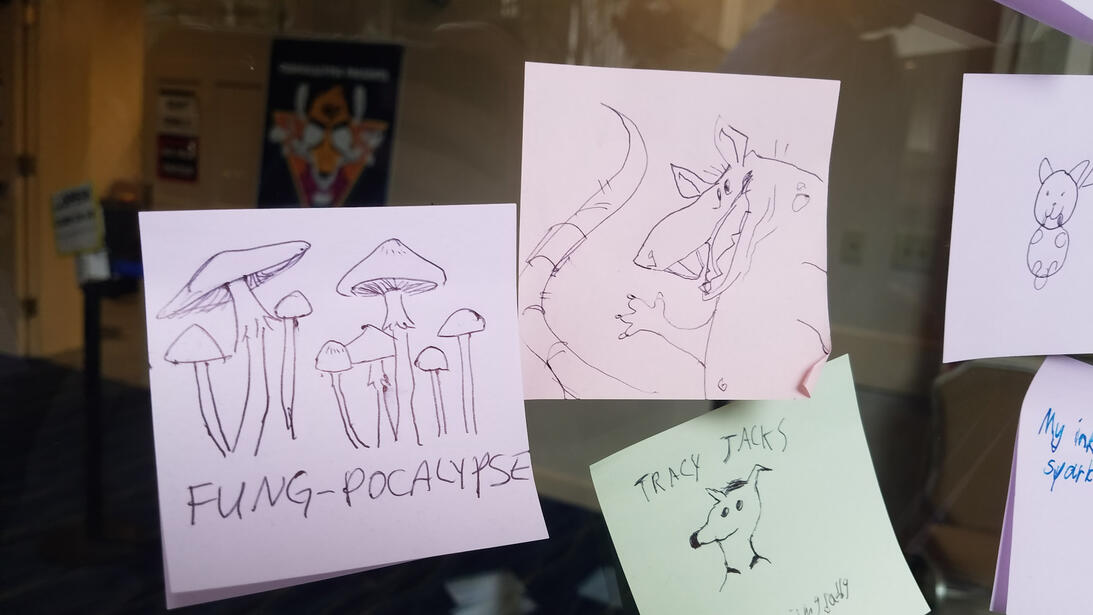 Some post-its on the wall, one reads &quot;fung-pocalypse&quot; with mushrooms and one has a rat