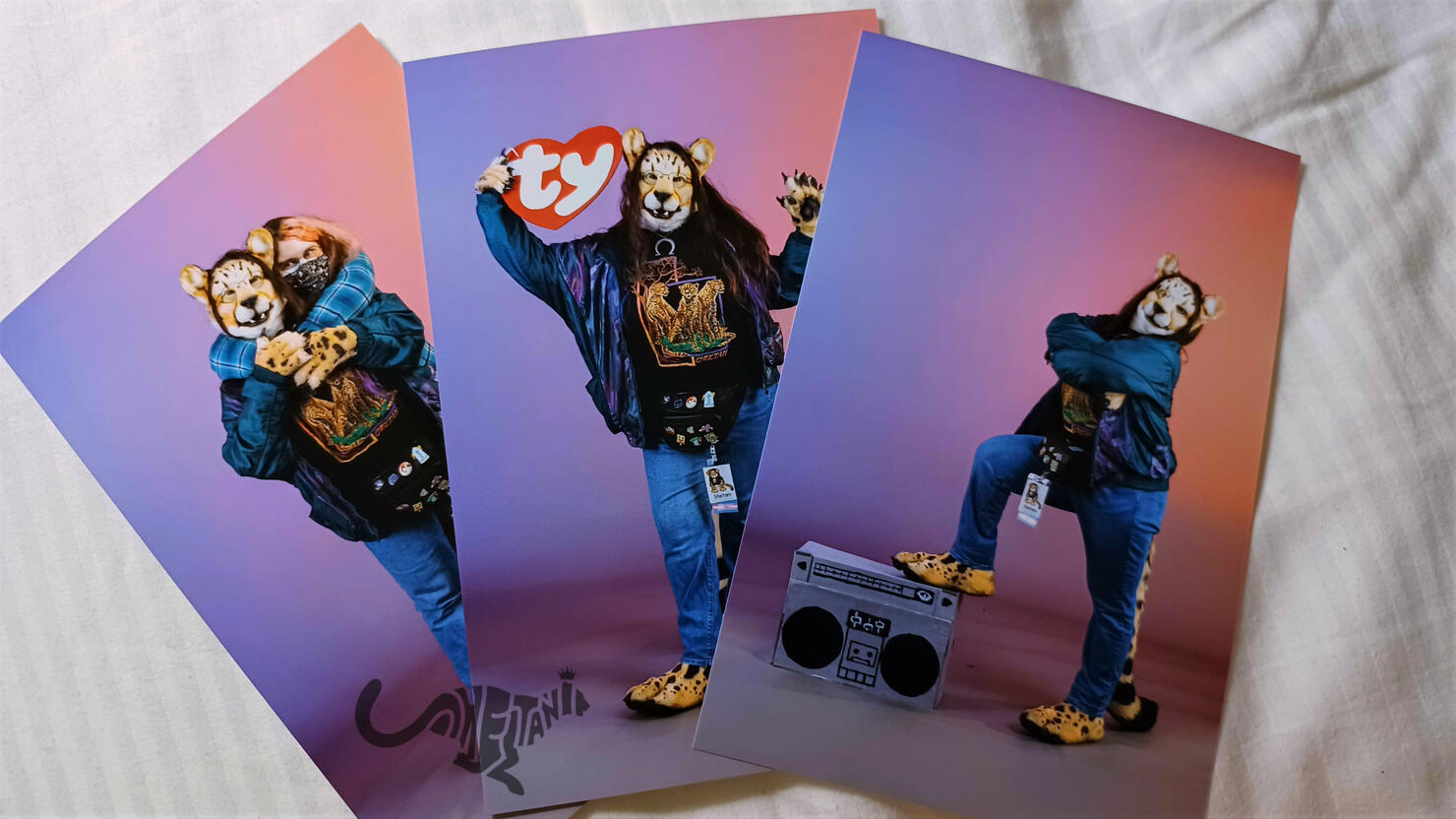 Snapshots on a bed of the previously mentioned photo, as well as Shetani standing with arms crossed and one footpaw up on a boom box, and being hugged from behind by her partner