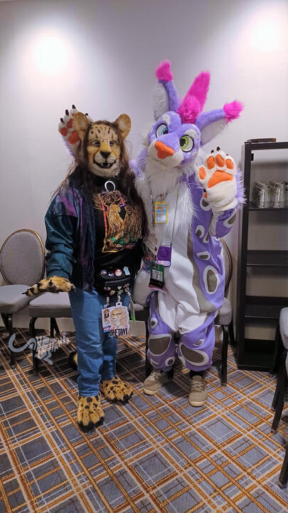 Shetani with Drifa, a purple and white lynx with pink mohawk wearing a kigurumi Shetani with Drifa, a purple and white lynx with pink mohawk wearing a kigurumi