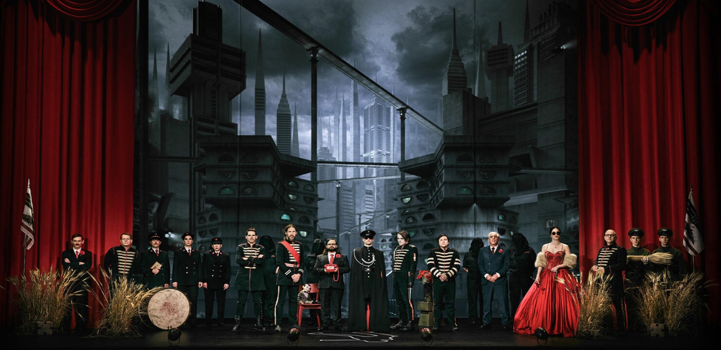 Promotional image showing many of the LLTBP characters on stage. There are 13 men and only 3 women, two of whom are (with all due respect) dressed identically in costumes indistinguishable from the surrounding men.