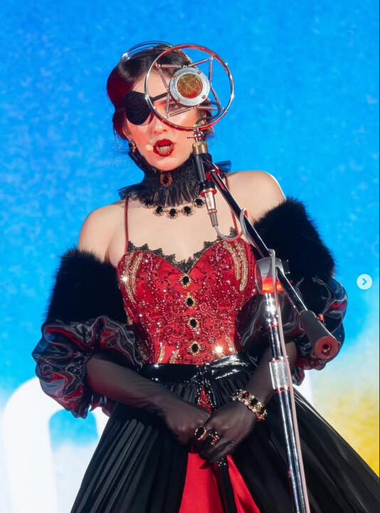 Close-up photo of Sylvia singing on stage. Close-up photo of Sylvia singing on stage.