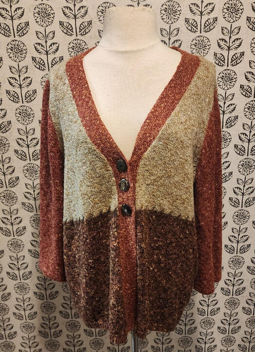 Product photo of a vintage knit cardigan with a deep V-neck and 3 buttons on the front. Variegated light and dark brown colorblock with sepia toned trim and sleeves.