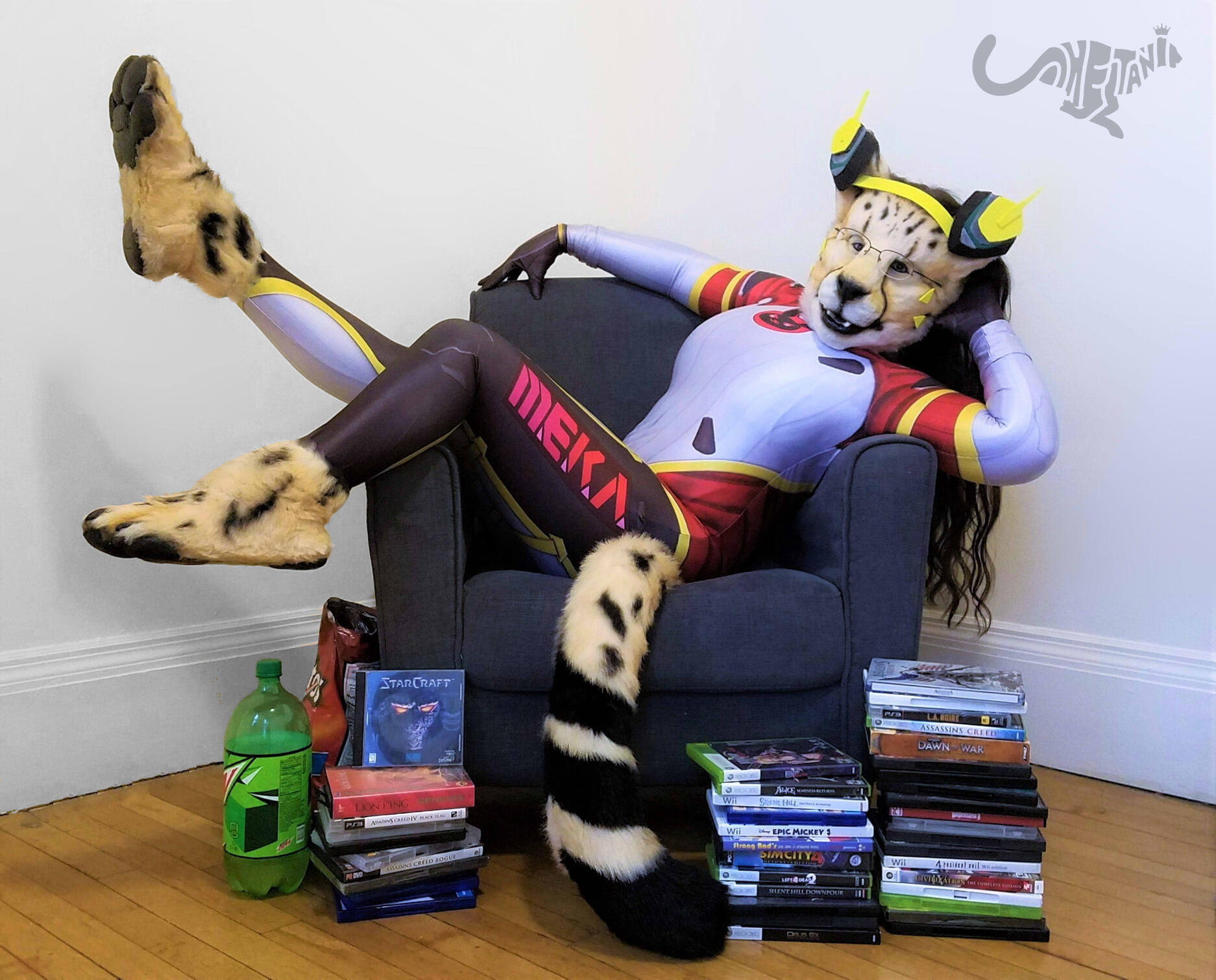 Shetani in cosplay as D.Va from Overwatch, lying back in an armchair in a pin-up pose. Video game cases, Mountain Dew, & Doritos